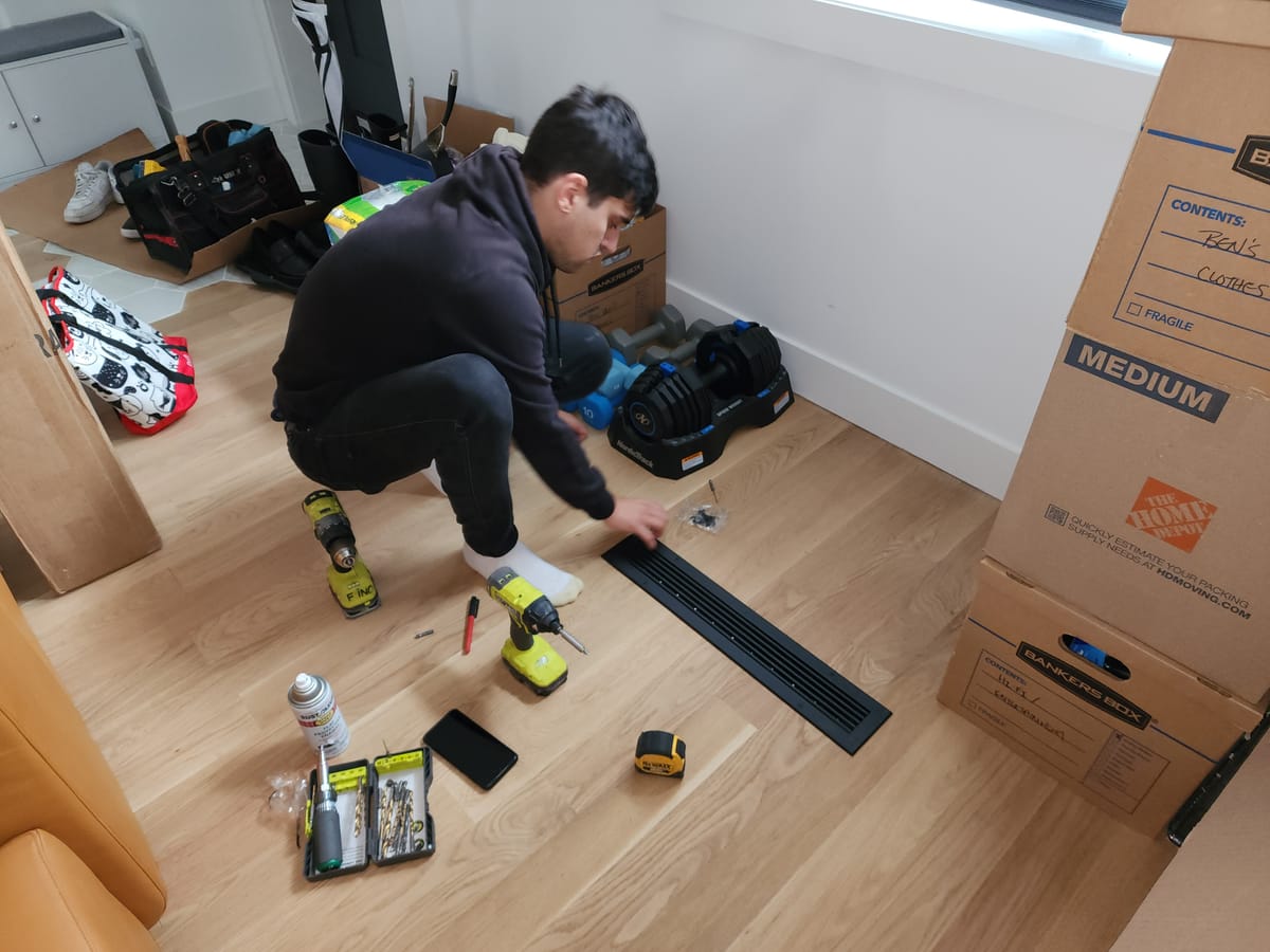 Technician installing black floor register vent