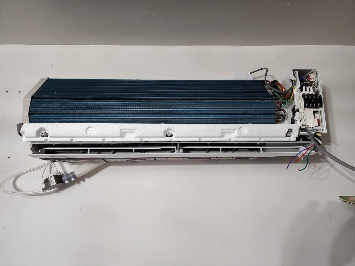 Mini split indoor unit with open cover showing evaporator coil