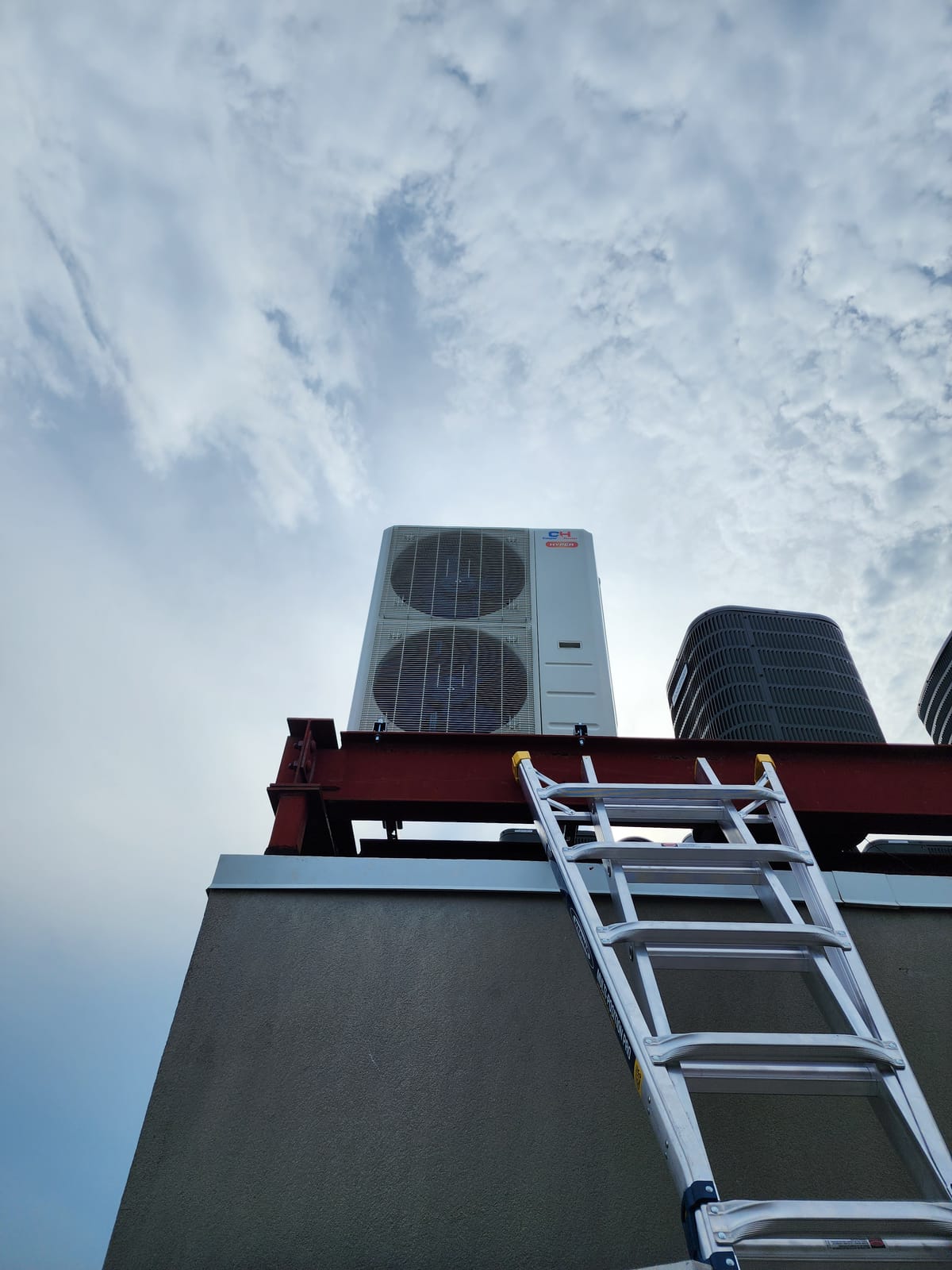 Large dual-fan condenser mounted on building wall bracket