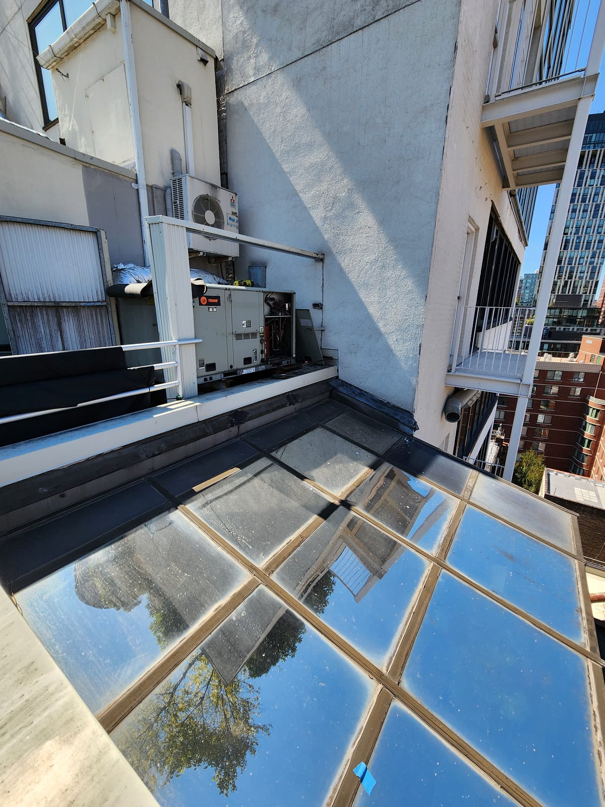 Rooftop condenser with NYC buildings and blue sky
