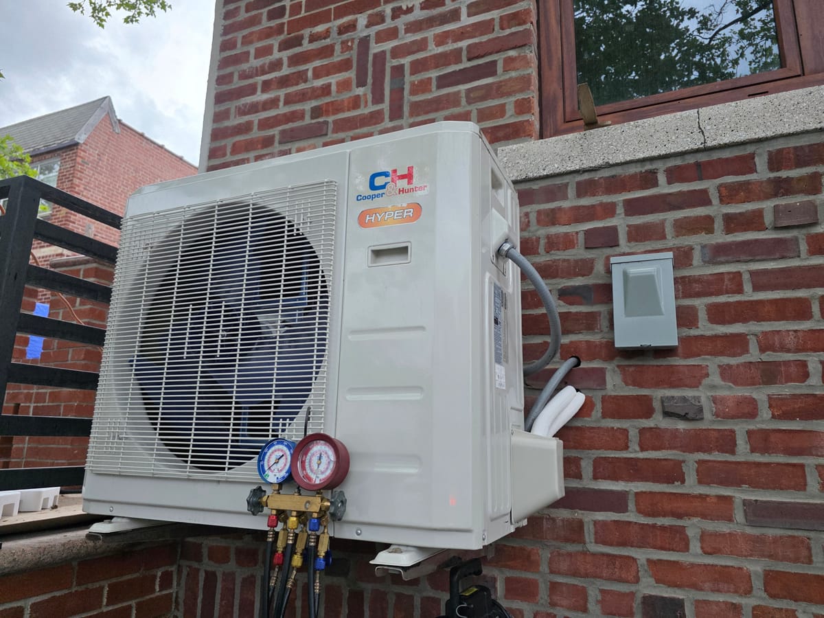 Cooper Hunter outdoor unit with gauges on brick wall
