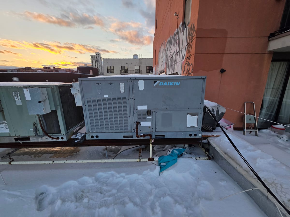 Daikin rooftop unit replacement in winter with old unit next to new